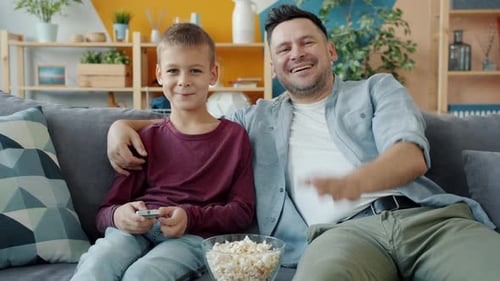 Father and Son Watching TV at Home