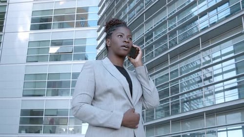 Serious Young Female Manager Standing Near Office Building
