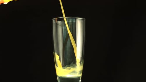 Bright Yellow Liquid Pouring into Glass