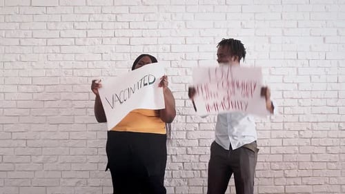 Smiling People Hold Vaccination Signs in Front of Wall