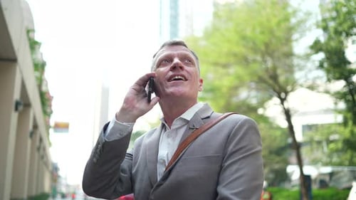 Man Talks on Phone Walking in Downtown