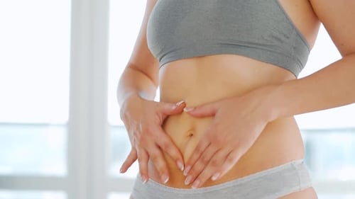 Femme enduit son estomac avec du gel contre les vergetures et fait de l'automassage