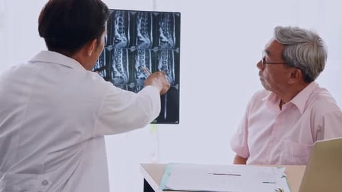 Expert doctor examining and explaining x-ray film to patient