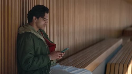 Young Adult Using Smartphone on a Bench