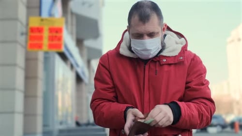 Man Wearing Protective Face Mask Bankrupt Arrears Counting Banknotes in the Wallet. Currency