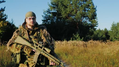 A Man in a Camouflage Bandanna and Walking Along a Country Road
