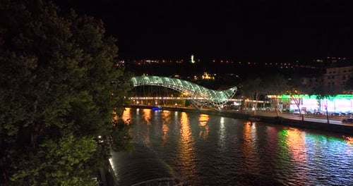 Night aerial view of Bridge of Peace and beautiful cityscape in the center of Tbilisi, Georgia 2022