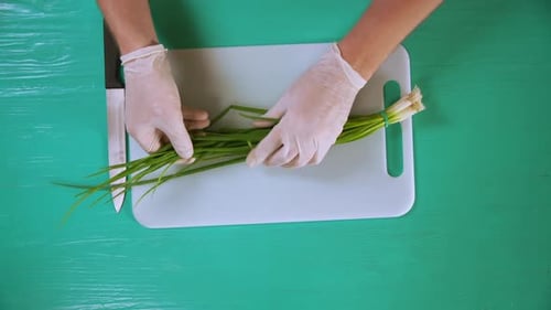 Chef Cook Cutting Green Onion on a White Board