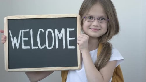 Smiling Child Holding a Welcome Sign