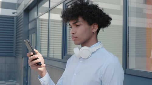 Happy Afro American Tourist in Headphones Listening to Music Outdoors Having Fun Alone in the Street