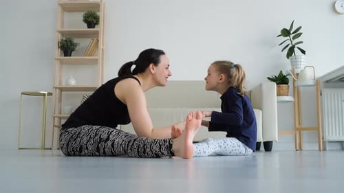 Woman and Child Stretching Together at Home