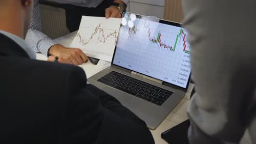 El jefe de la empresa toma algunas notas sobre el gráfico con el resultado de las ventas en