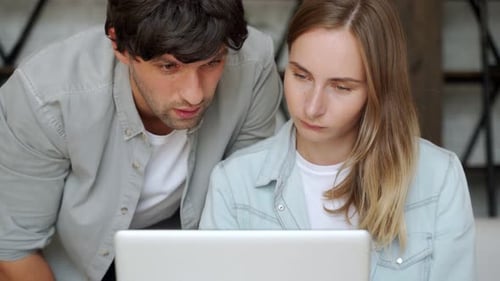 Young Adults Looking at Laptop Together Indoors