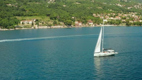 White Sailboat or Yacht Sails on the Sea with Blue Water