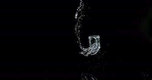 Glas Wasser prallt und spritzt auf schwarzem Hintergrund, Zeitlupe 4K