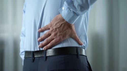 Man Rubbing Lower Back in Pain