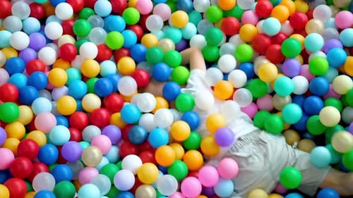 Smiling Boy Playing in a Colorful Ball Pit
