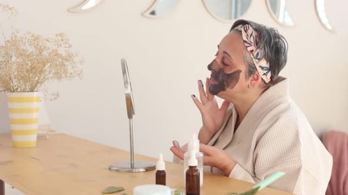 Woman Applying Cosmetic Mask at Home