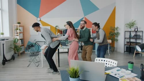 Slow Motion of Happy Young People Colleagues Dancing Having Fun in Office
