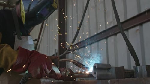Slow motion of a welder welding construction steel frames