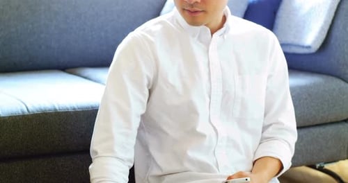 Man Using Phone and Laptop in Home