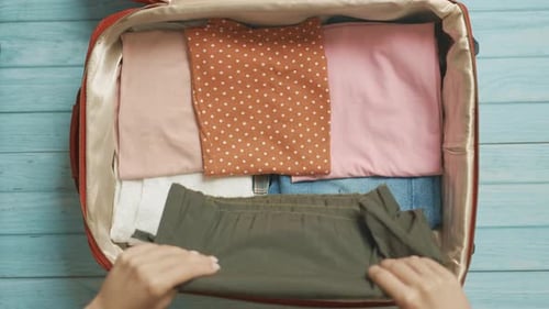 A Traveler Woman is Getting Ready for Travel and Packing Clothes