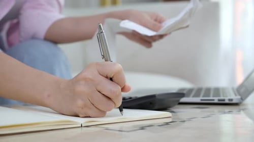 Woman Works on Home Finances With Calculator