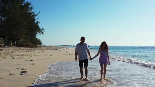Romantic couple happy together on perfect tourist beach voyage by blue sea and white sandy backgroun