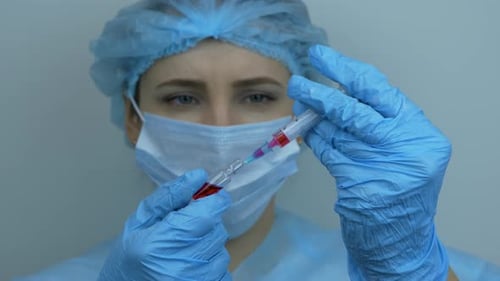 Technician carefully preparing syringe for injection. Preventive medications for coronavirus COVID