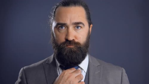 Man in Suit Adjusting His Tie