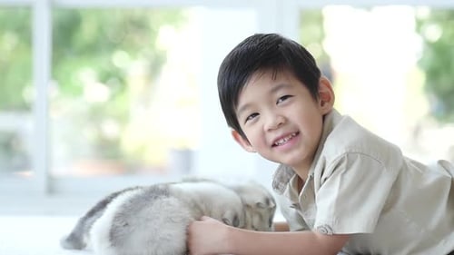 Boy Cuddling Adorable Puppy Indoors