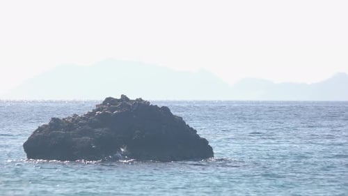 Felsen im welligen Meer an einem Sommertag