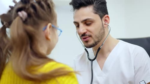 Caring Doctor Listens to Child's Heart With Stethoscope