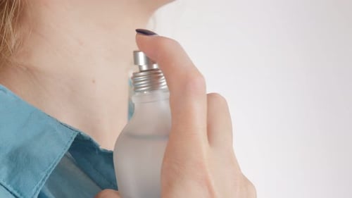 Woman Applying Perfume on Neck in Close Up