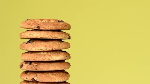 Tower of golden chocolate chip cookies on yellow