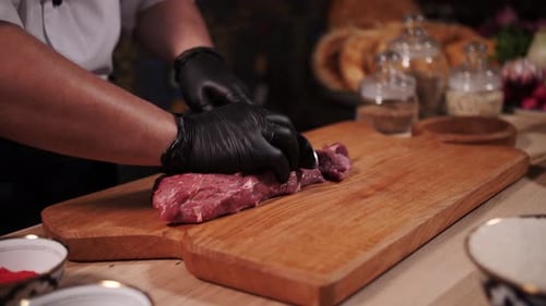 Chef Slicing Raw Meat With a Knife