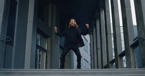 Glücklicher Geschäftsmann mit aufgeregtem Gesichtsausdruck und fing an zu tanzen und zu lächeln, erfolgreicher Mann