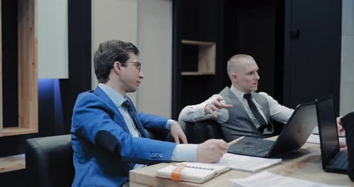 Professionals Collaborate on Technology in Modern Office