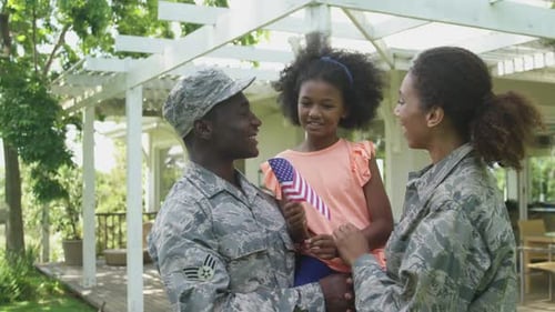 Military Family Standing Outdoors in Sunny Backyard
