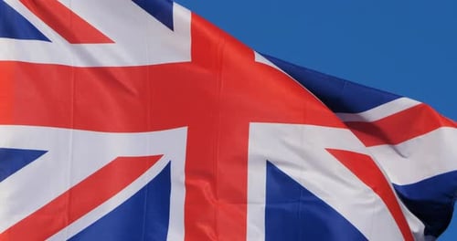 British Flag Flowing Against Clear Blue Sky
