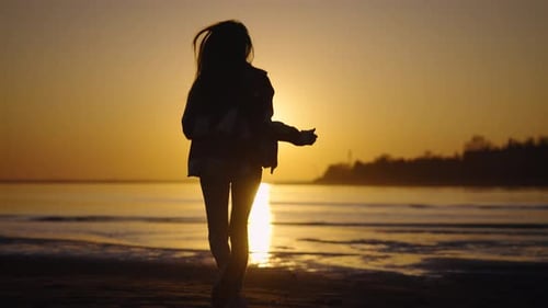 Girl Enjoying Scenic Sunset on a Sandy Beach
