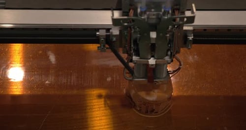 Close-up of mechanism of 3D printer working on printing plastic toys