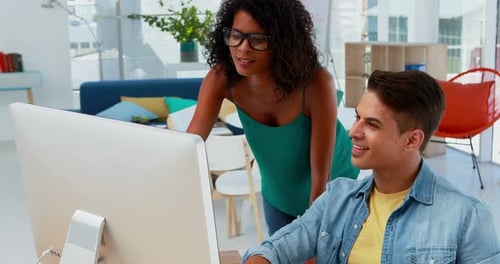 Colleagues Collaborating at Computer in Modern Office