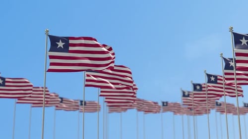 Waving Liberia National Flags Against Clear Blue Sky