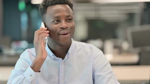 Happy Young Adult Talking on Mobile Phone