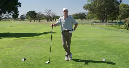 Caucasian male golfer smiling at camera on a golf course