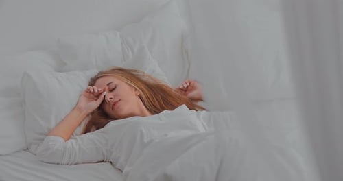 Woman Waking Up and Stretching in Bed