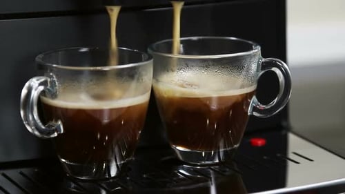 Espresso Machine Fills Two Glass Mugs with Coffee