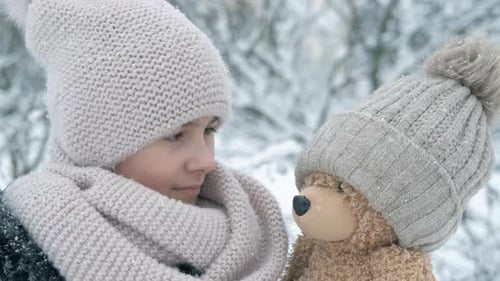 Child and Teddy Bear in the Winter Snow