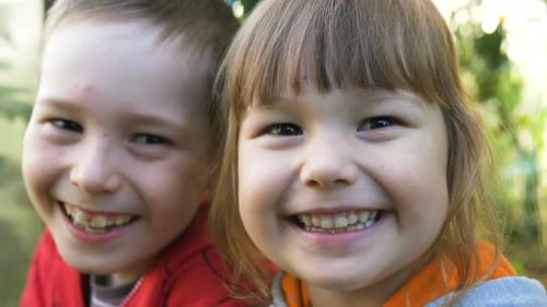 Little Funny Boy and Girl Laugh in Green Garden Close View